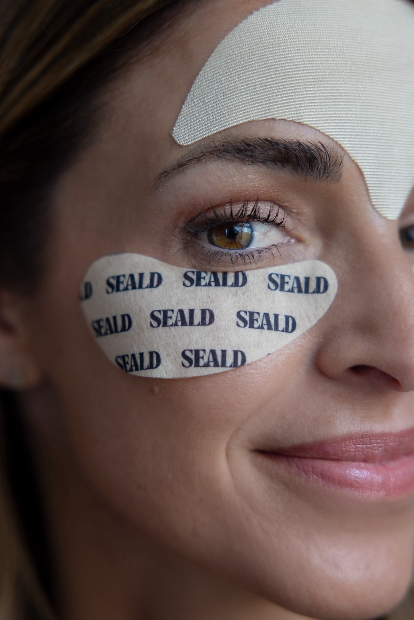 Close-up of a woman's face with SEALD patches on her eyes.